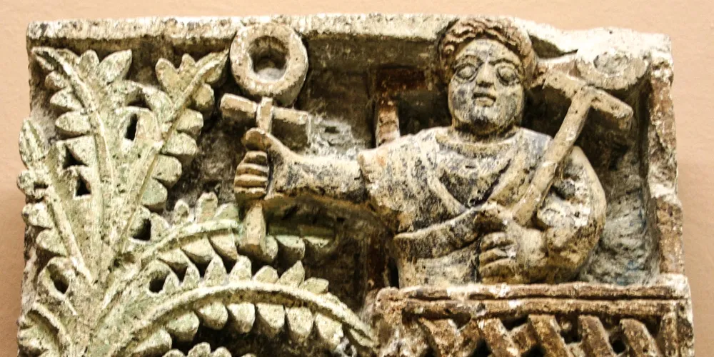 Ancient stone relief carving showing ankh symbol and religious figures